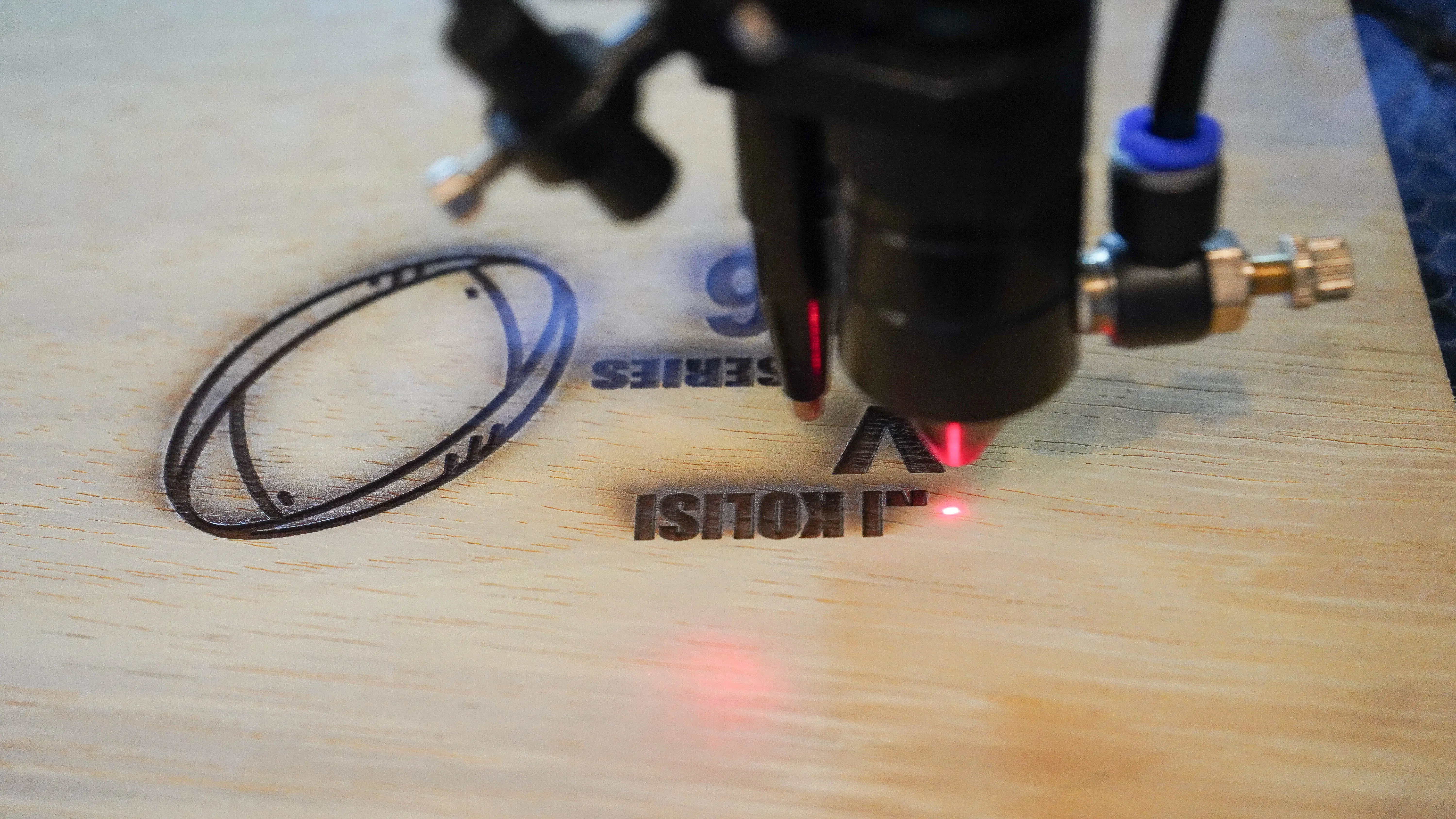 Close-up of the laser engraving a custom design into wood